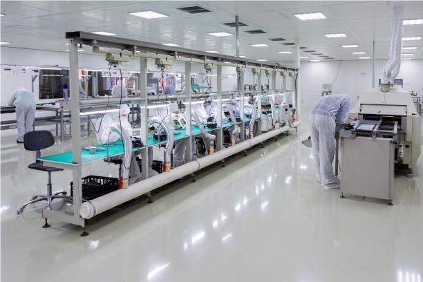 Operators in cleanroom garments at an assembly line in a medical-device cleanroom